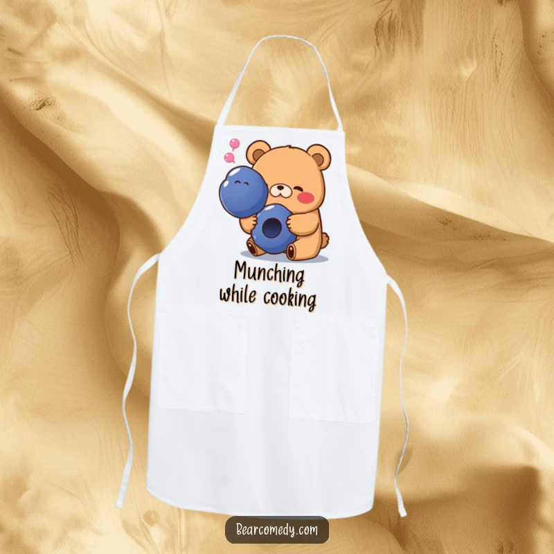 Funny apron showing a bear with a happy sigh, happily eating a giant blueberry, perfect for a joyful cooking experience.