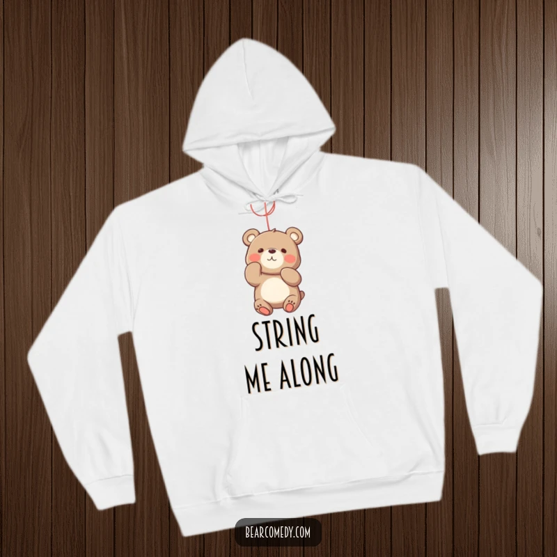 Funny bear hoodie with a playful character energetically batting at a bright, dangling string, capturing a moment of fun.